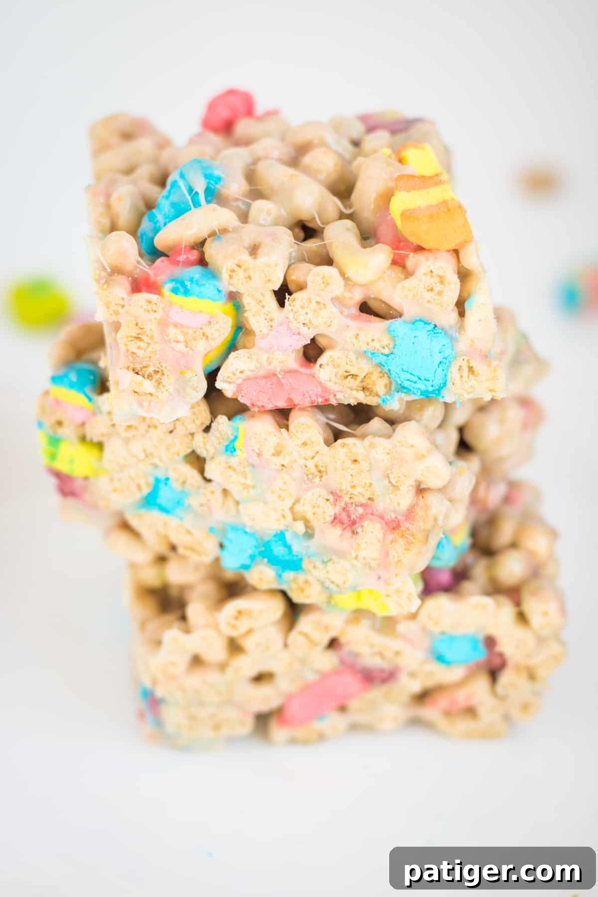 Magical Lucky Charms Treats 2 Three lucky charms marshmallow cereal bars cut into squares and stacked on top of one another on a white plate
