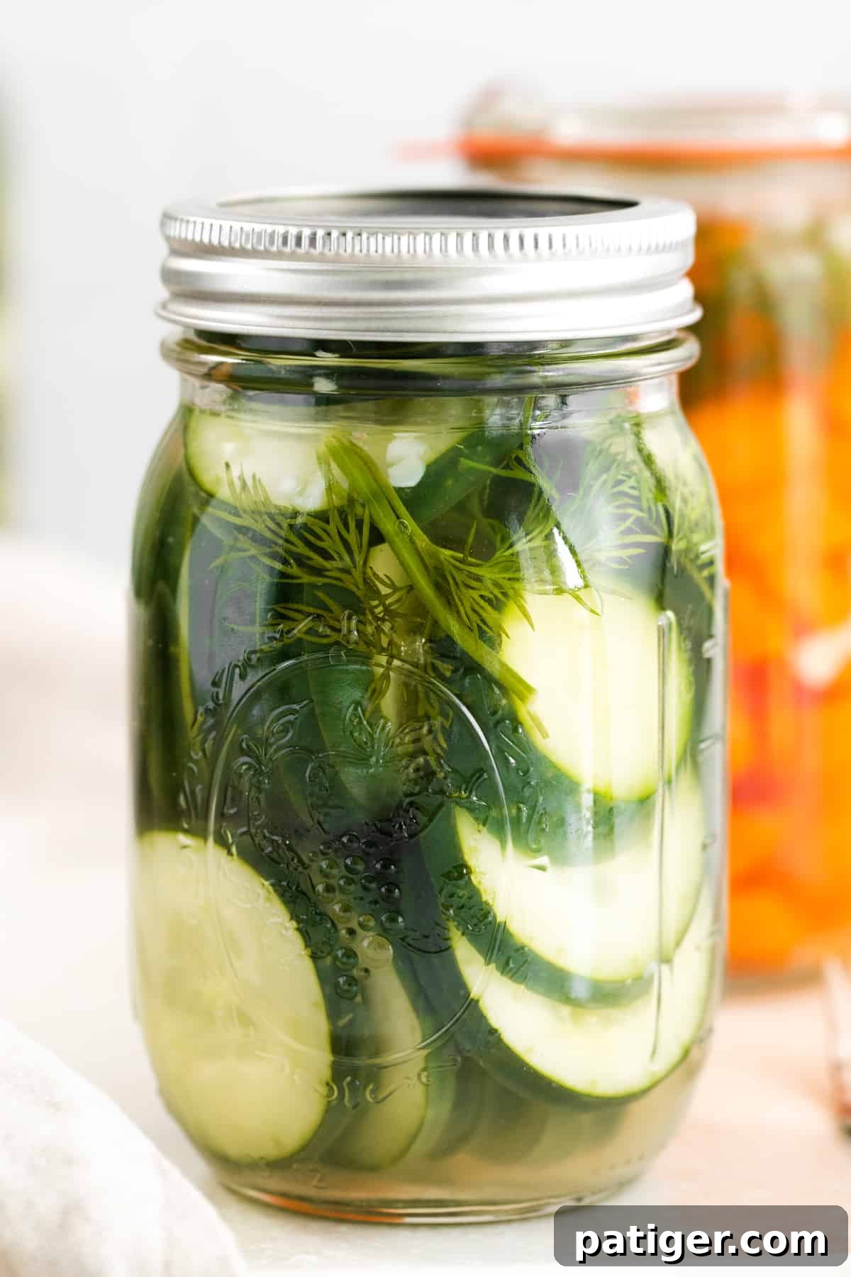 Effortless Fridge Pickles 2 Mason jar filled with sliced pickled cucumbers, ready for refrigeration