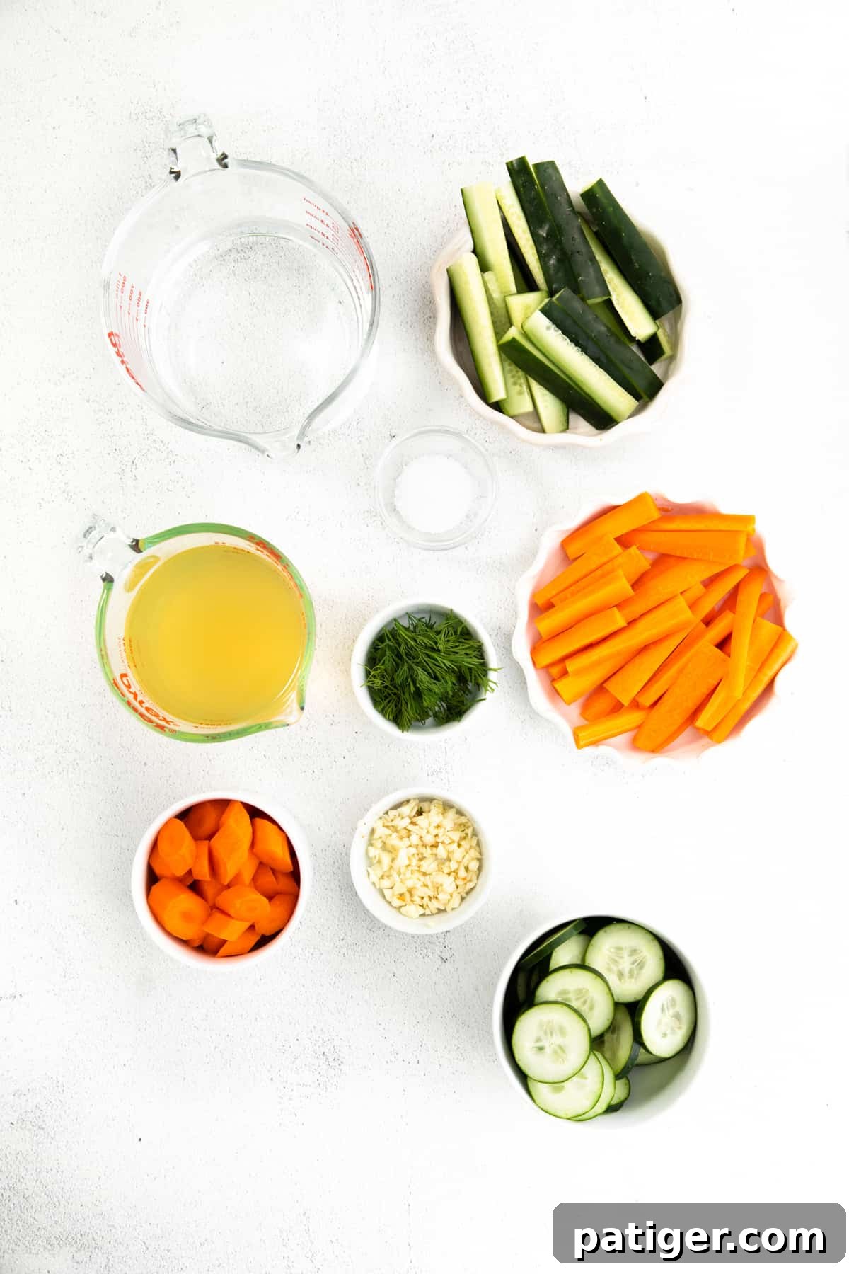 Effortless Fridge Pickles 4 Ingredients for quick pickles displayed in bowls: water, vinegar, cucumber spears, cucumber slices, carrot spears, carrot slices, garlic, dill, and salt.