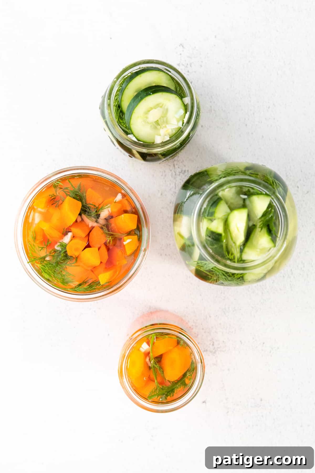 Effortless Fridge Pickles 7 Mason jars filled with cucumbers and carrots, fully covered in hot brine.