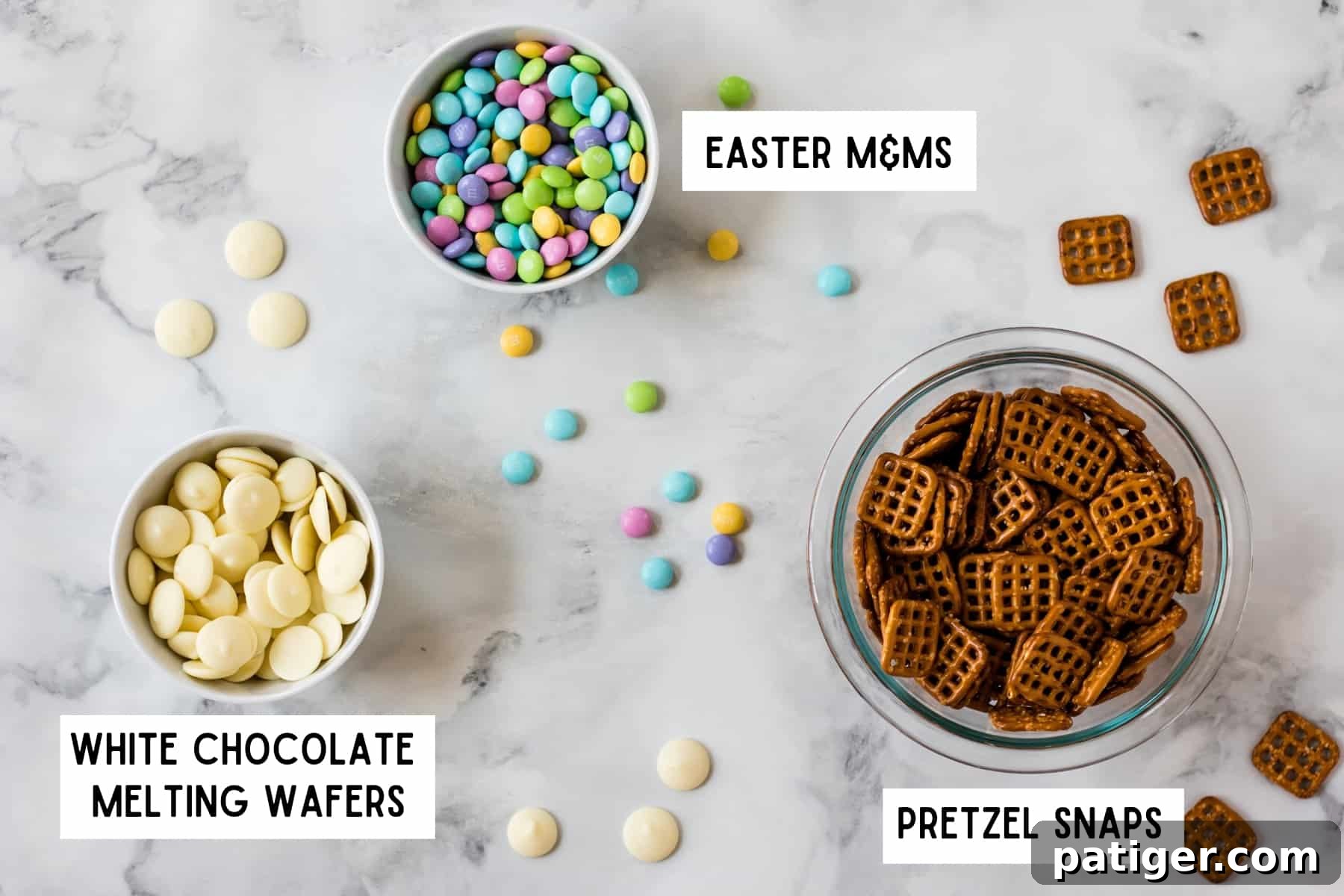 3 bowls on counter top: white chocolate melting wafers, Easter M&Ms, and pretzel snaps