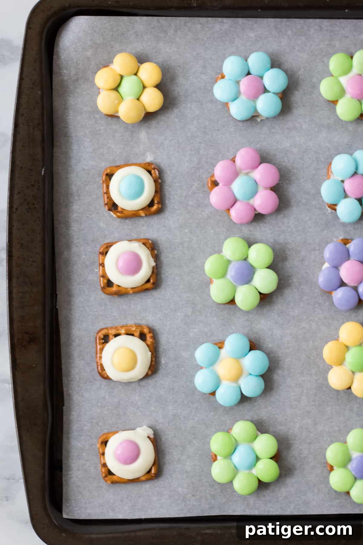 Flower pretzel bites completed and in progress. The in progress bites have an M&M in the center of each but do not yet have their "petals"