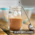 homemade apple pie spice in a small mason jar with small scoop next to it