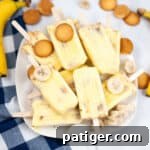 Banana popsicles piled on a platter with nilla wafers and frozen banana slices