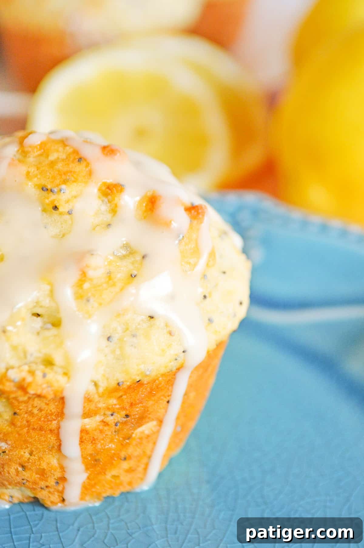 Zesty Lemon Poppy Seed Muffins 3 Close-up of a single lemon muffin, showcasing its golden-brown top, speckled with poppy seeds and generously coated in a glistening lemon glaze.