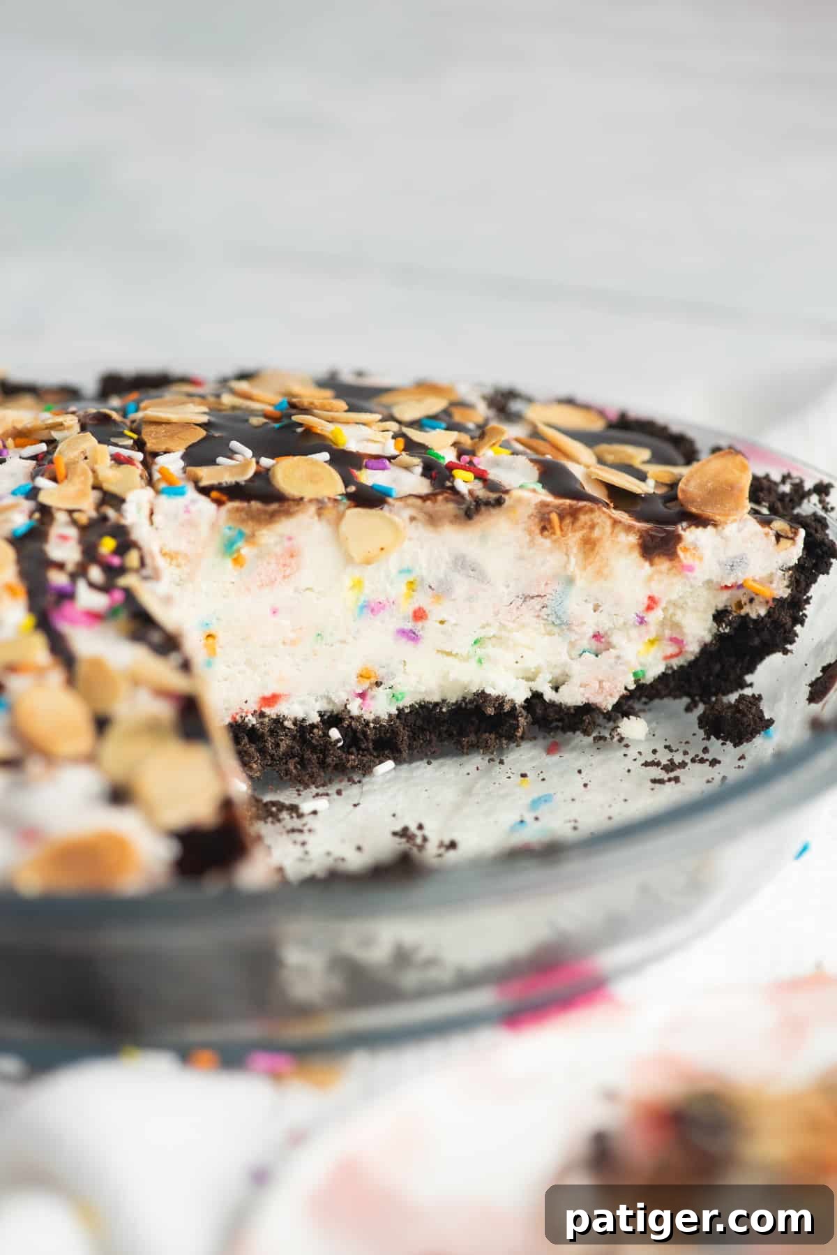 Icebox Indulgence 3 Ice cream cake in a glass pie plate. Vanilla ice cream pie is in chocolate cookie crust and topped with sprinkles and chocolate sauce