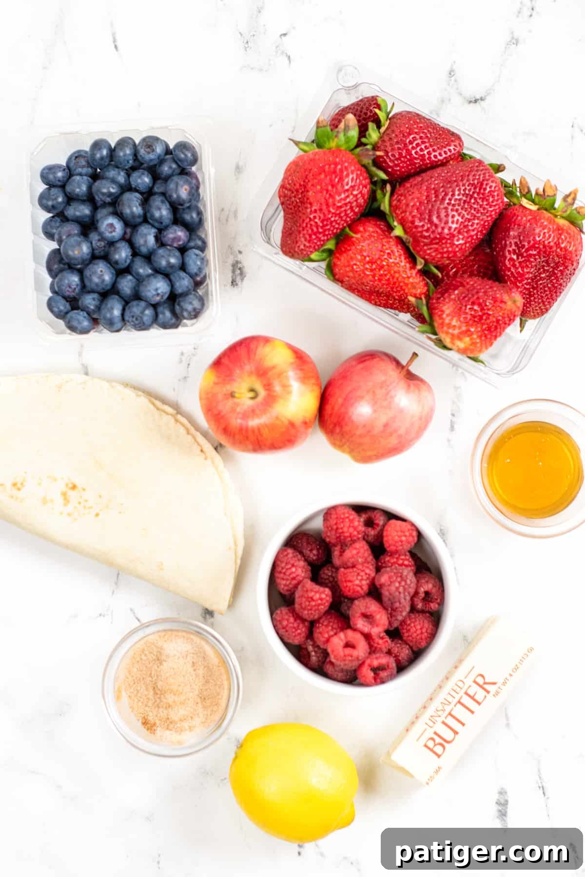 Fruit Salsa Ingredients: pint of blueberries, 16 oz package of strawberries, bowl of raspberries, 2 red apples, lemon juice, tortillas, butter, sugar, and ground cinnamon