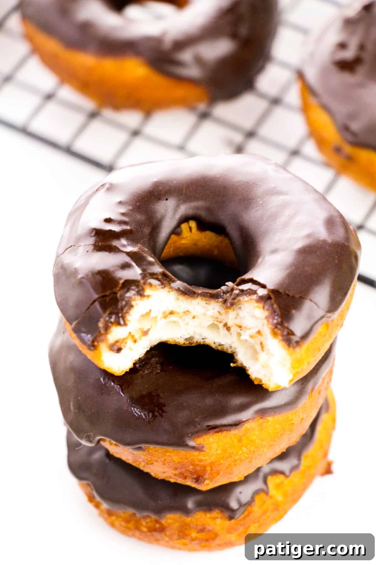 Choco-Biscuit Bliss Bites 2 Stack of chocolate glazed biscuit doughnuts with a bite taken out of the top one