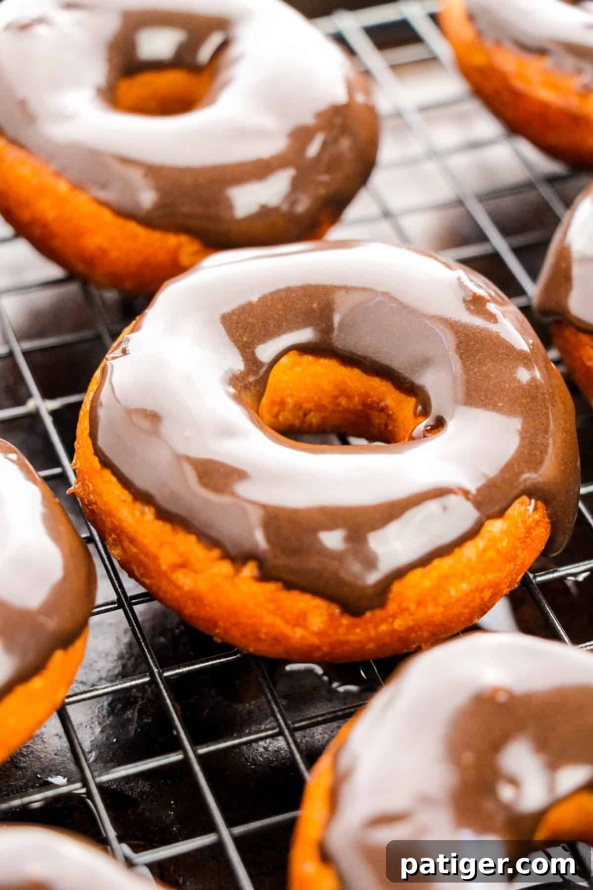 Choco-Biscuit Bliss Bites 3 Biscuit donuts with chocolate glaze on set on wire cooling rack atop of sheet pan