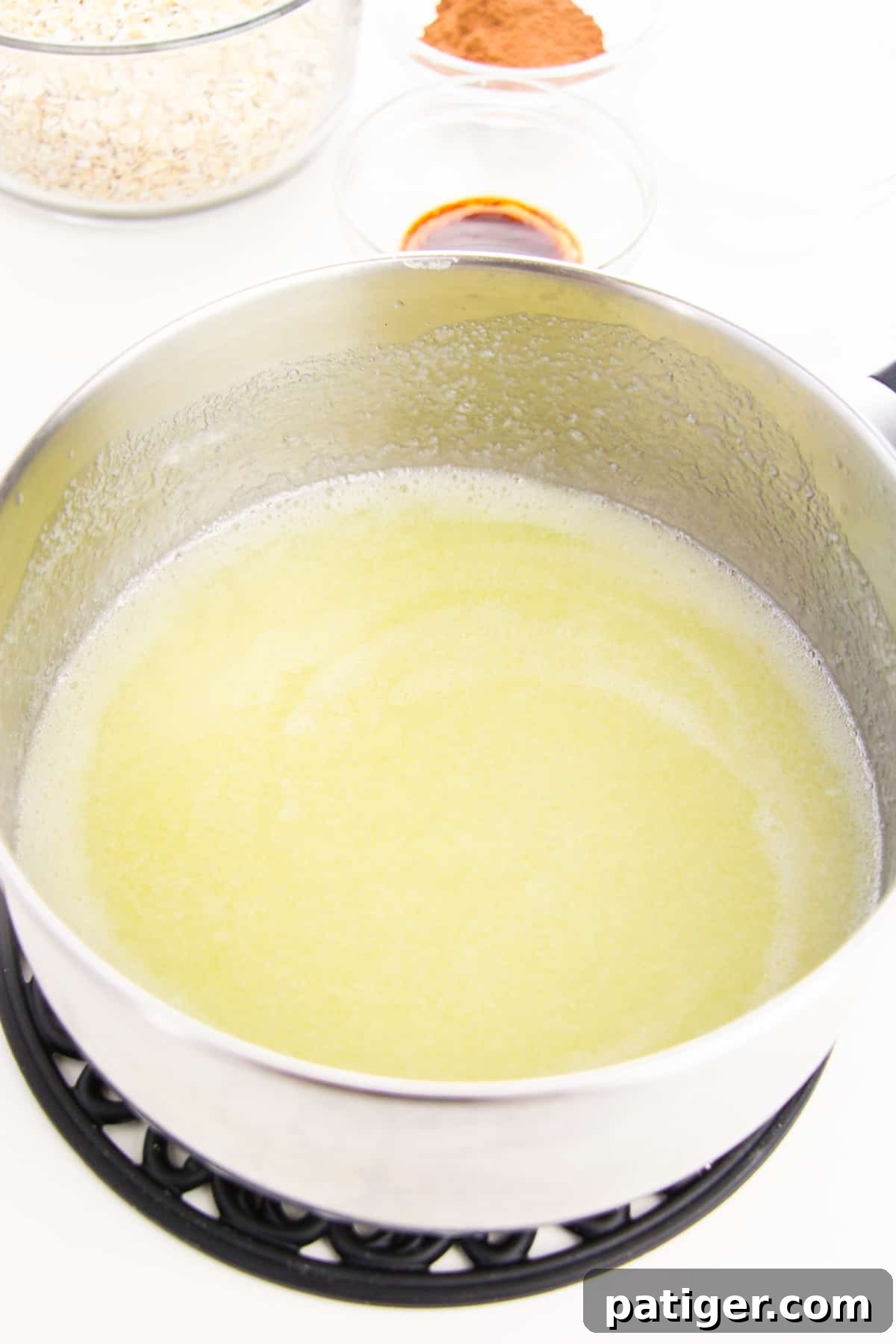 Butter, milk, and white sugar in saucepan with additional ingredients in background