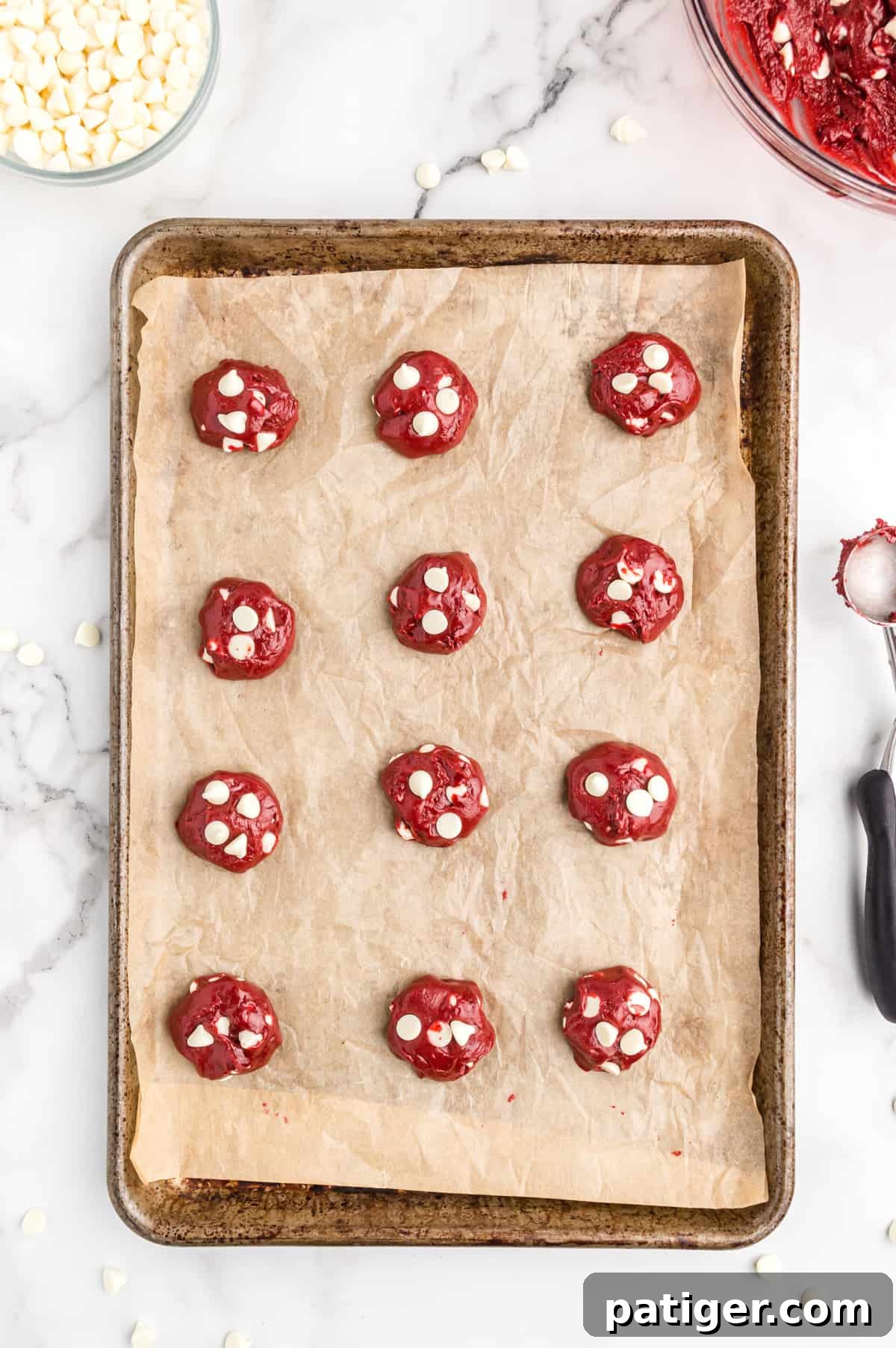 12 balls of cookie dough on parchment lined baking sheet