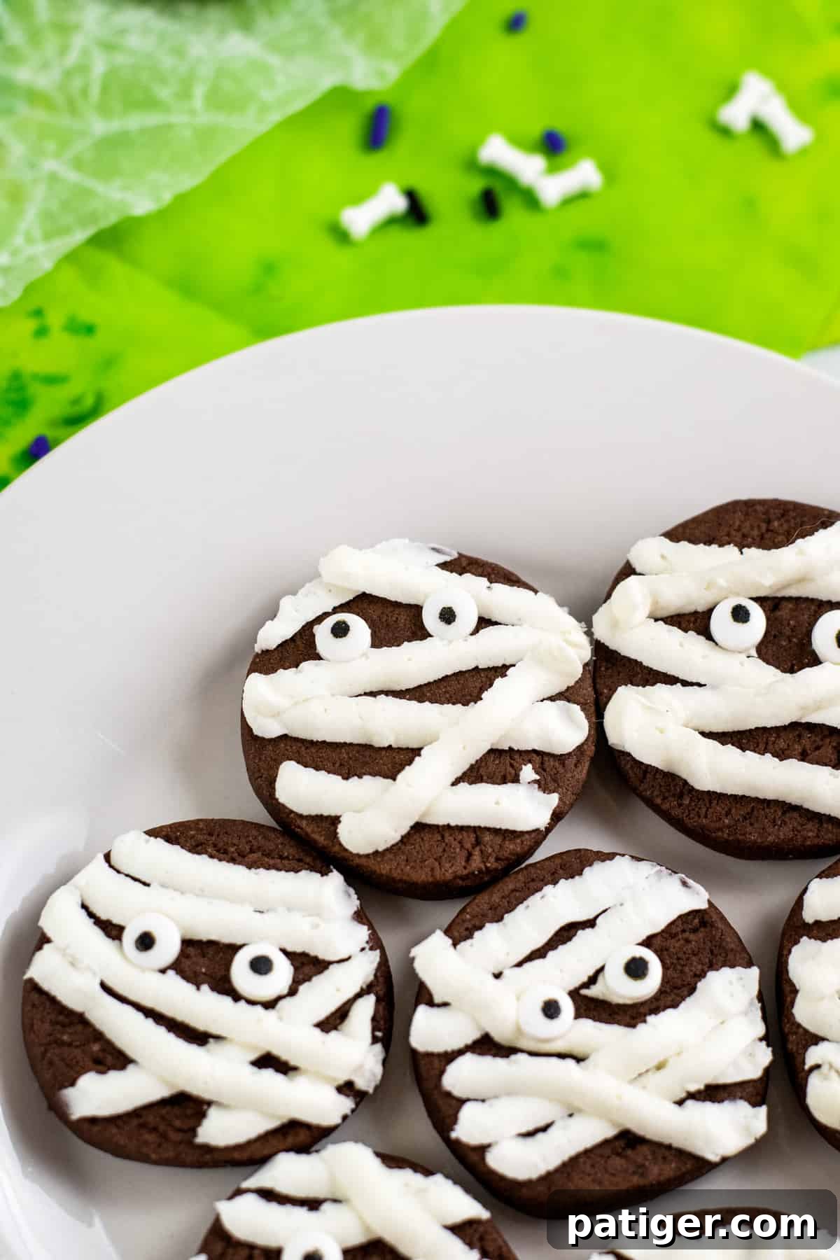 chocolate mummy cookies with strips of whit frosting and candy eyes