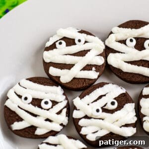 chocolate mummy cookies with strips of whit frosting and candy eyes