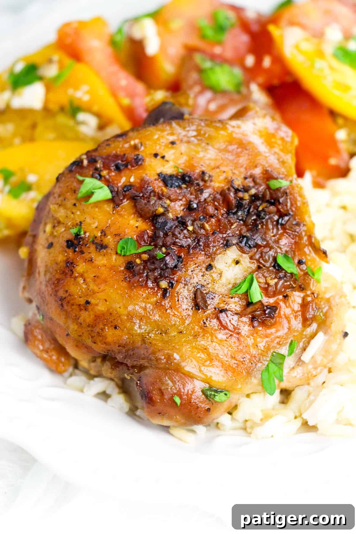 Crockpot brown sugar garlic chicken thigh served over rice with tomato salad