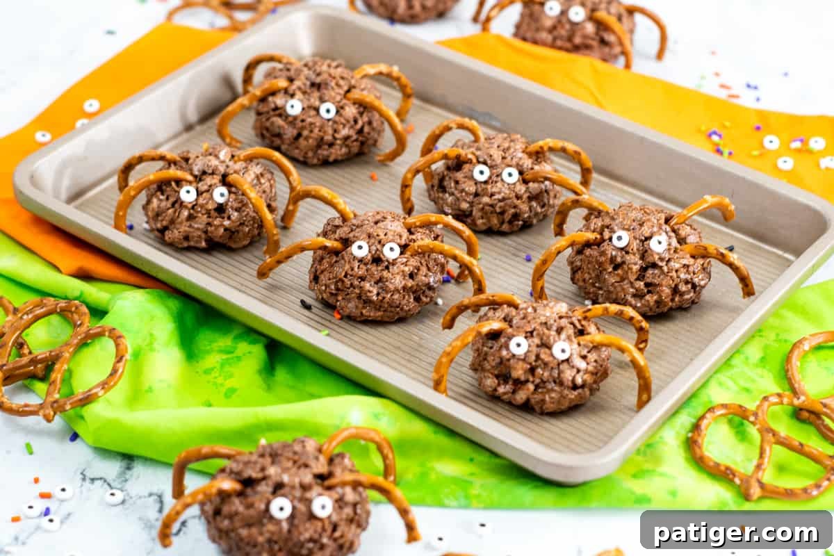 A delicious chocolate rice krispies spider treat, decorated with pretzel legs and candy eyes, ready to be devoured at a Halloween gathering.
