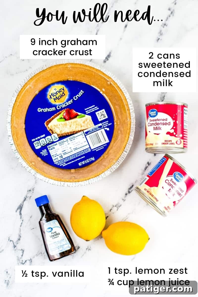 Arrangement of ingredients on a kitchen countertop: a 9-inch Honey Maid graham cracker crust, two cans of store-brand sweetened condensed milk, two fresh lemons, and a bottle of vanilla extract, all set for making lemon icebox pie.