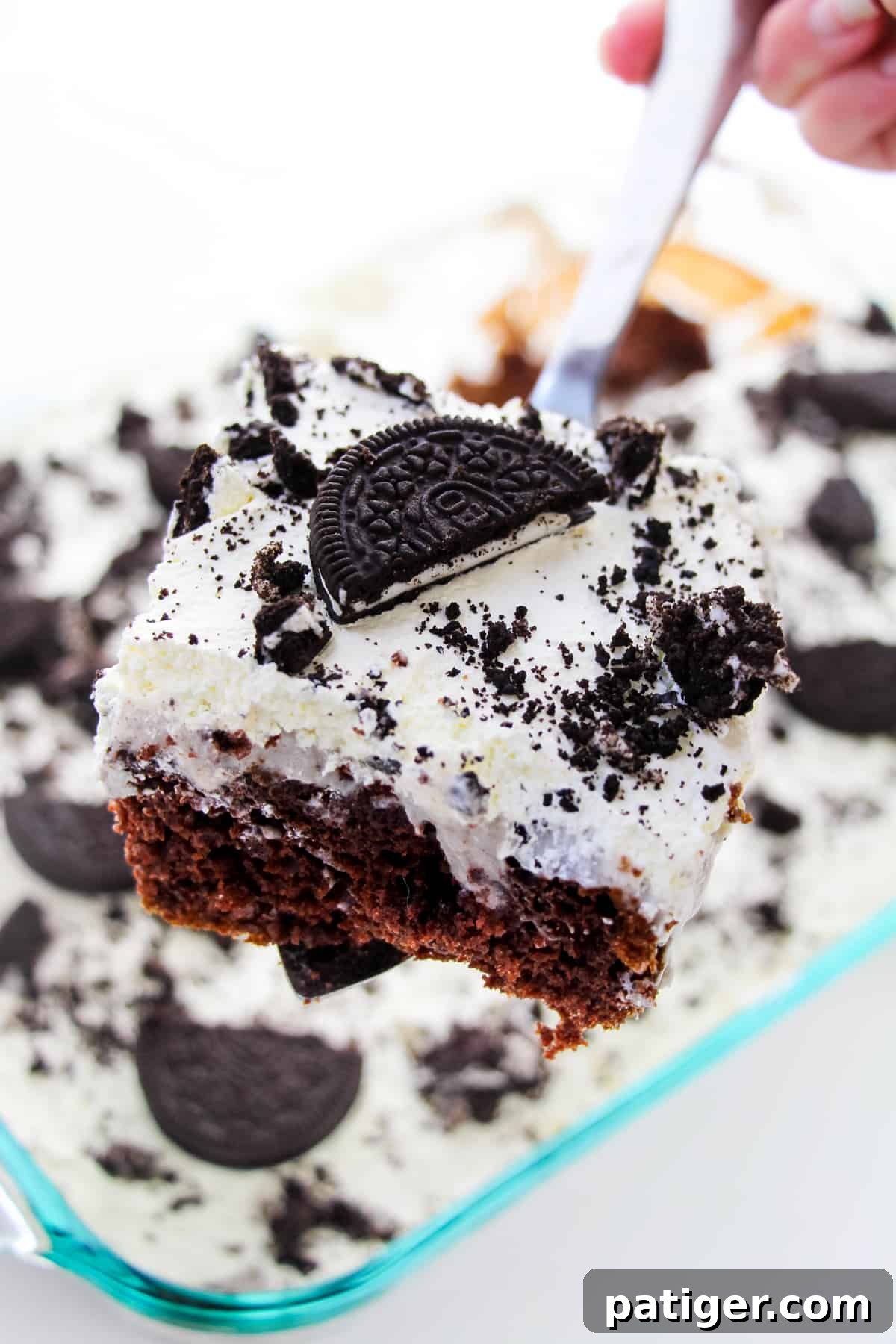 Cookies & Cream Poke Perfection 3 Square piece of OREO pudding poke cake being removed from pan with a spatula