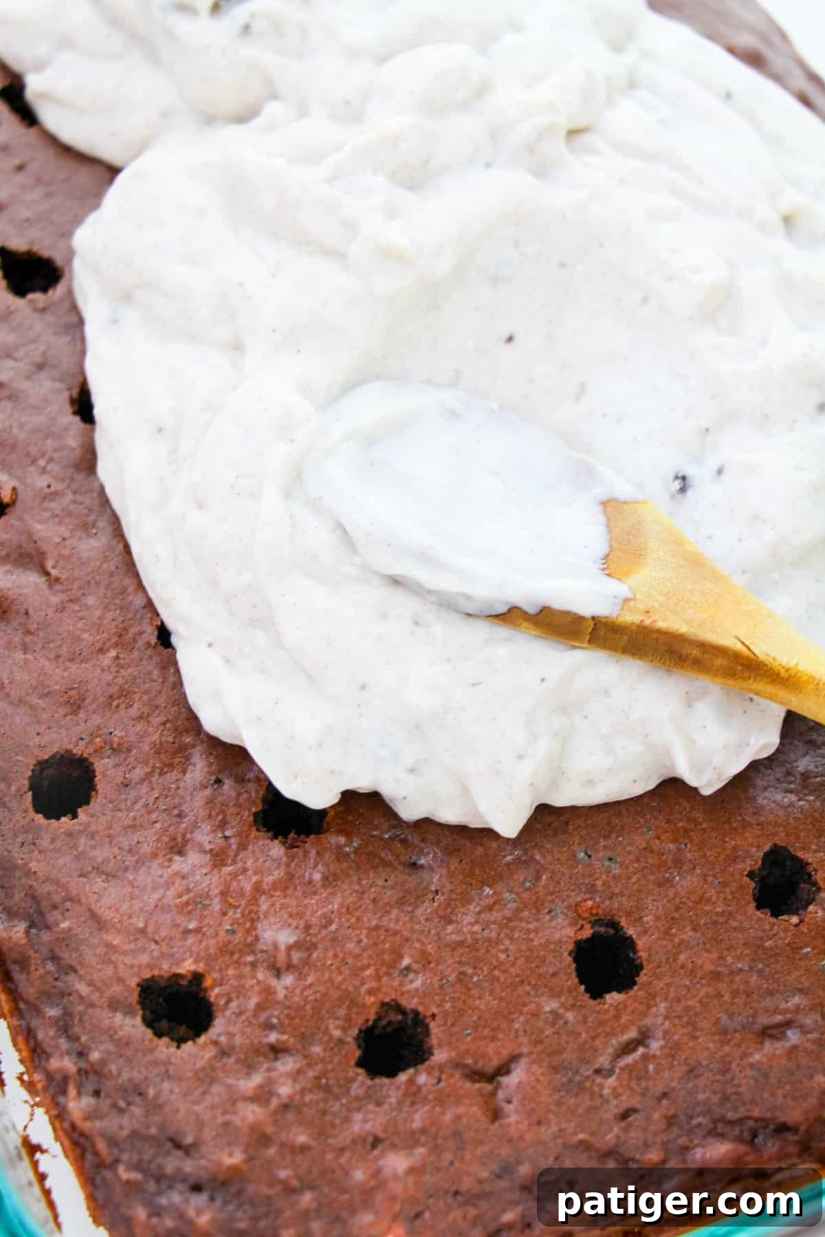 Cookies & Cream Poke Perfection 7 Pudding being spooned on top of poke cake