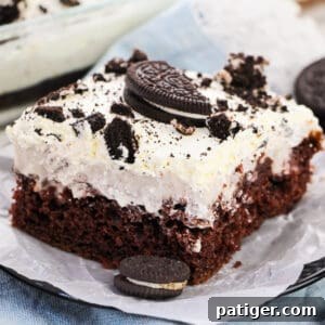 OREO Poke Cake topped with Cool Whip and pieces of OREOs