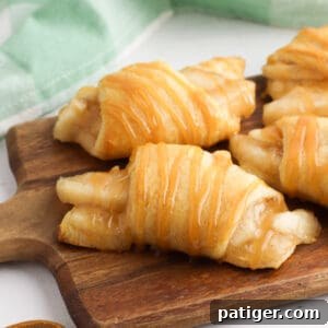 Crescent rolls filled with apple pie filling and drizzles with caramel sauce