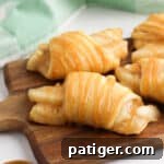 Crescent rolls filled with apple pie filling and drizzles with caramel sauce