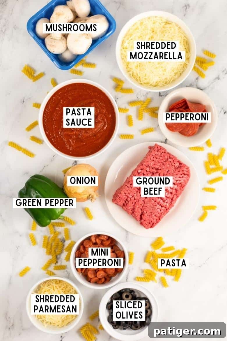 Fresh ingredients for Pizza Pasta Casserole including Rotini pasta, ground beef, mini pepperoni, pasta sauce, green pepper, onion, mushrooms, black olives, and shredded cheeses.