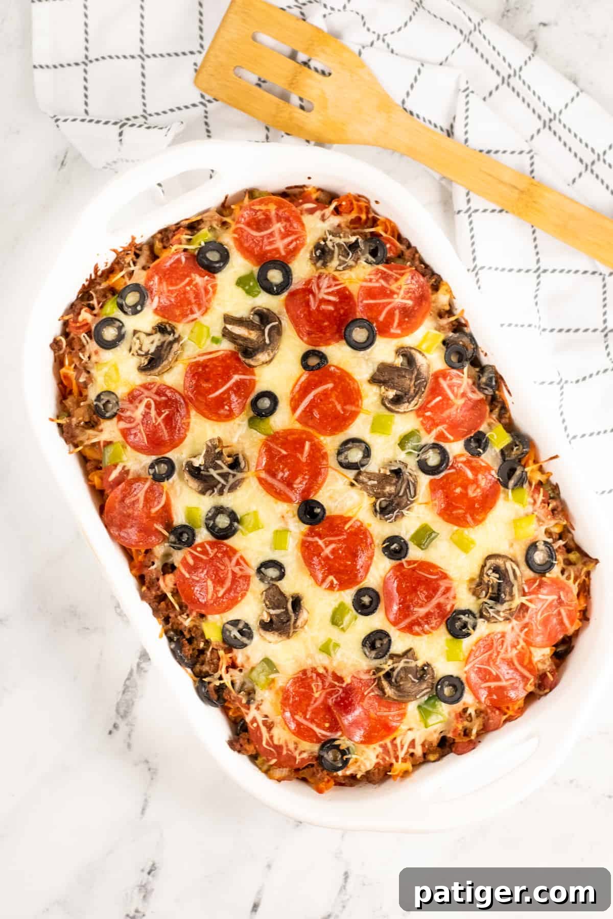 Baked Cheesy Pizza Pasta Casserole fresh out of the oven, topped with pepperoni, olives, peppers, and mushrooms