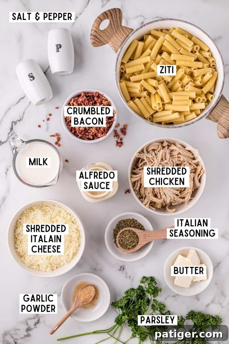 Golden Alfredo Chicken Bake 5 Ingredients for Chicken Alfredo Casserole laid out on a countertop: ziti pasta, salt and pepper, crumbled bacon, shredded chicken, Italian seasoning, shredded Italian cheese, butter, alfredo sauce, milk, garlic powder, and fresh parsley.