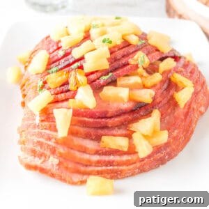 Pineapple Glazed Air Fryer Ham served on white platter topped with fresh pineapple