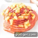 Pineapple Glazed Air Fryer Ham served on white platter topped with fresh pineapple