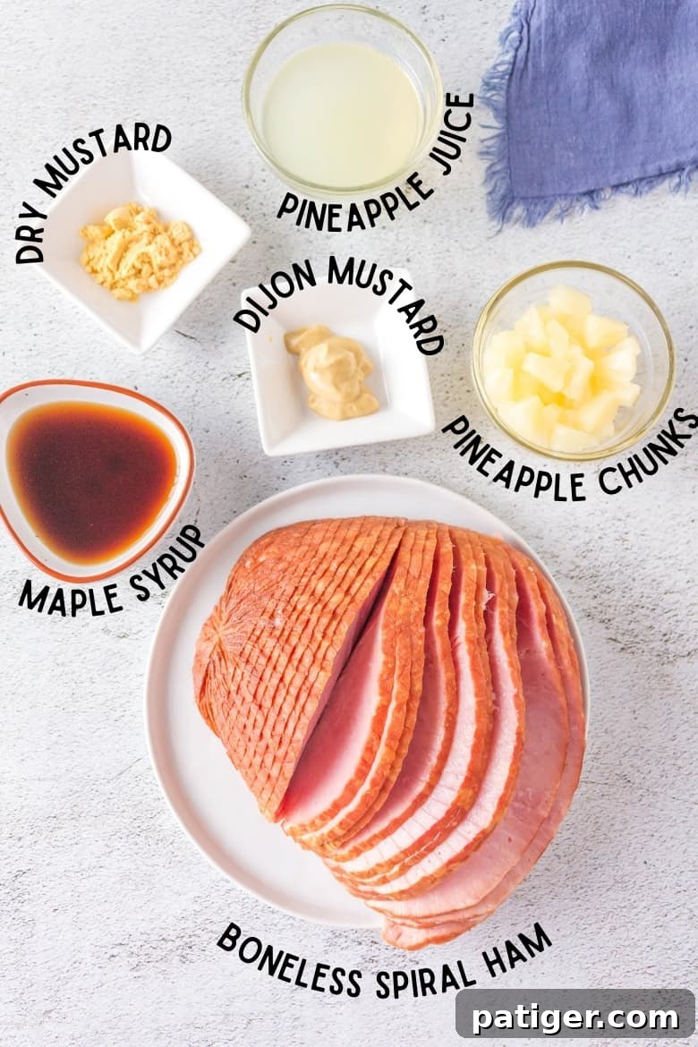 A top-down view displaying all the necessary ingredients neatly arranged on a kitchen countertop: a boneless spiral-cut ham, jars of Dijon and dry mustard, a can of pineapple chunks, a bottle of pure maple syrup, and a container of pineapple juice.