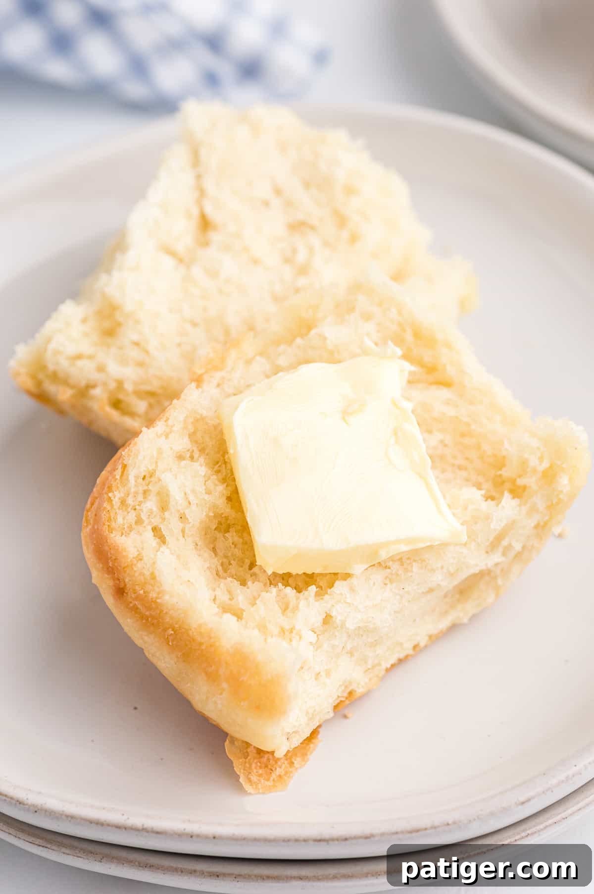 Fluffy potato roll cut in half with a pat of butter on it