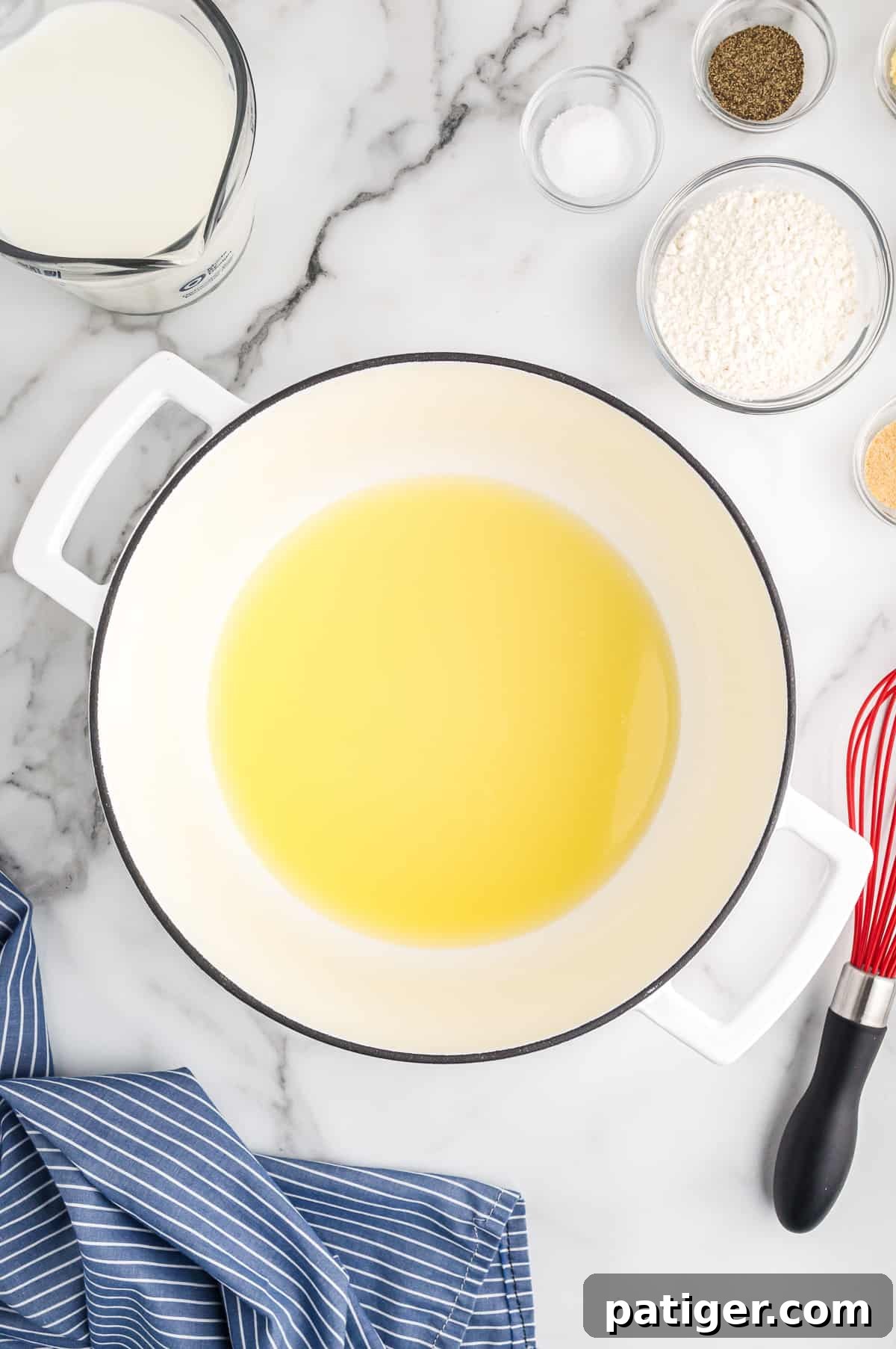 Buffalo Bliss Mac & Cheese 5 A large white pot on a stovetop, containing perfectly melted unsalted butter, ready for the next step in making the cheese sauce.