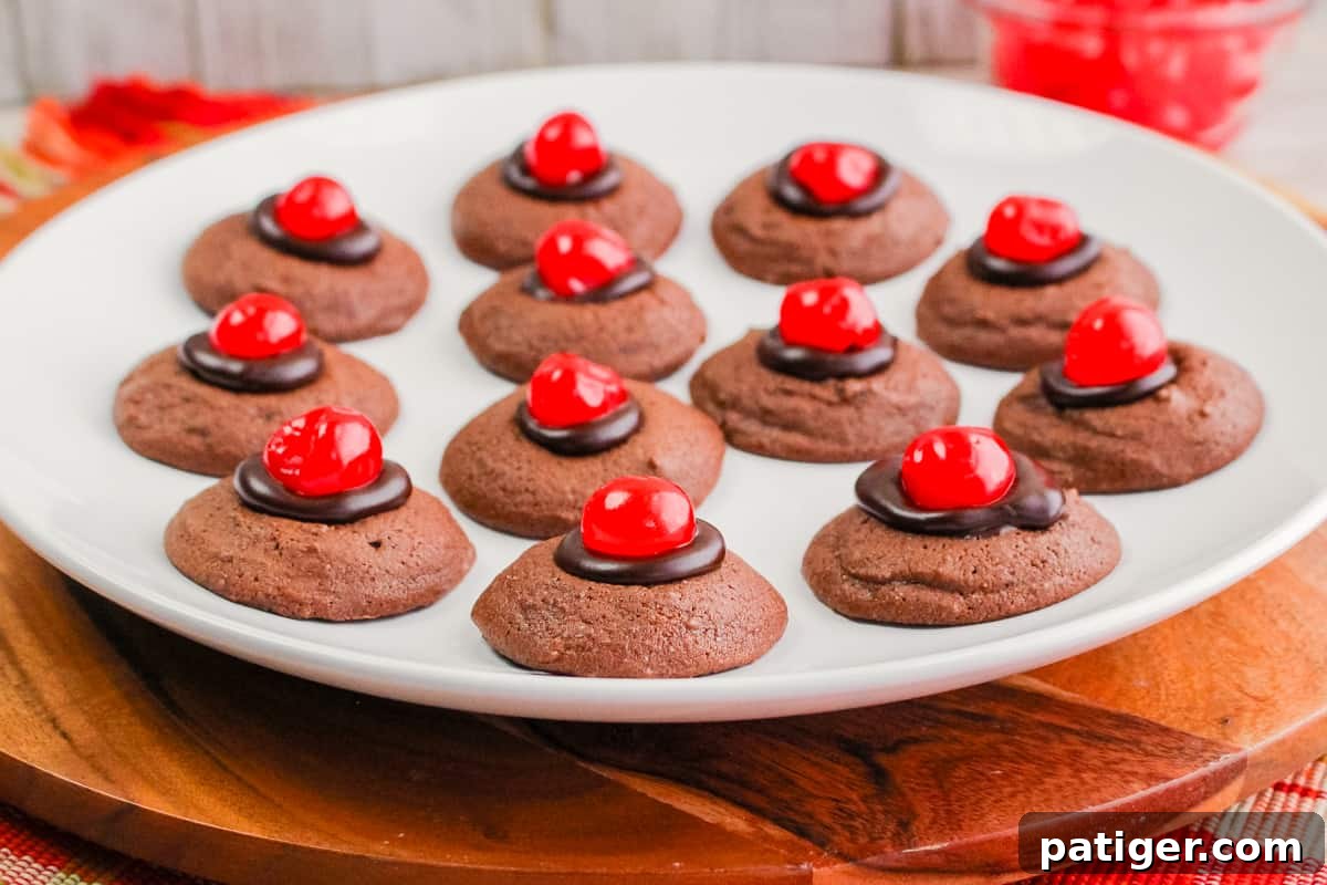 A stunning plate of Chocolate Cherry Thumbprint Cookies with maraschino cherries, artfully arranged and ready to be served at any gathering.