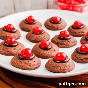 Chocolate cherry thumbprint cookies on a white plate, ready to be served