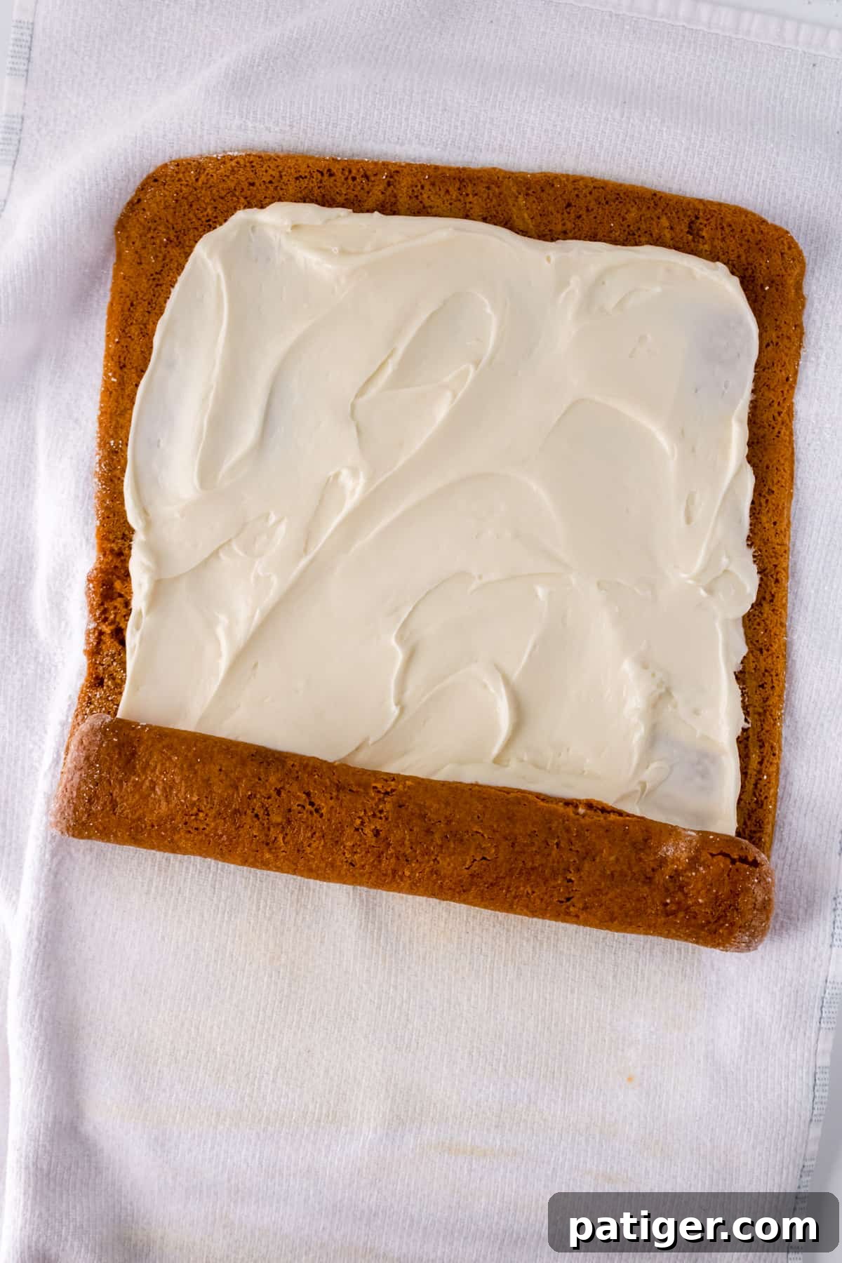 Spiced Pumpkin Swirl Cake 11 Pumpkin cake with cream cheese filling being re-rolled into a log shape.