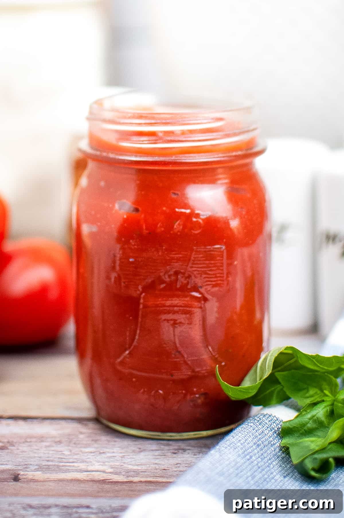 Homemade pizza sauce from tomato paste in a mason jar on a rustic wooden table, ready for use.