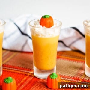 Pumpkin jello shot topped with whipped cream and candy pumpkin