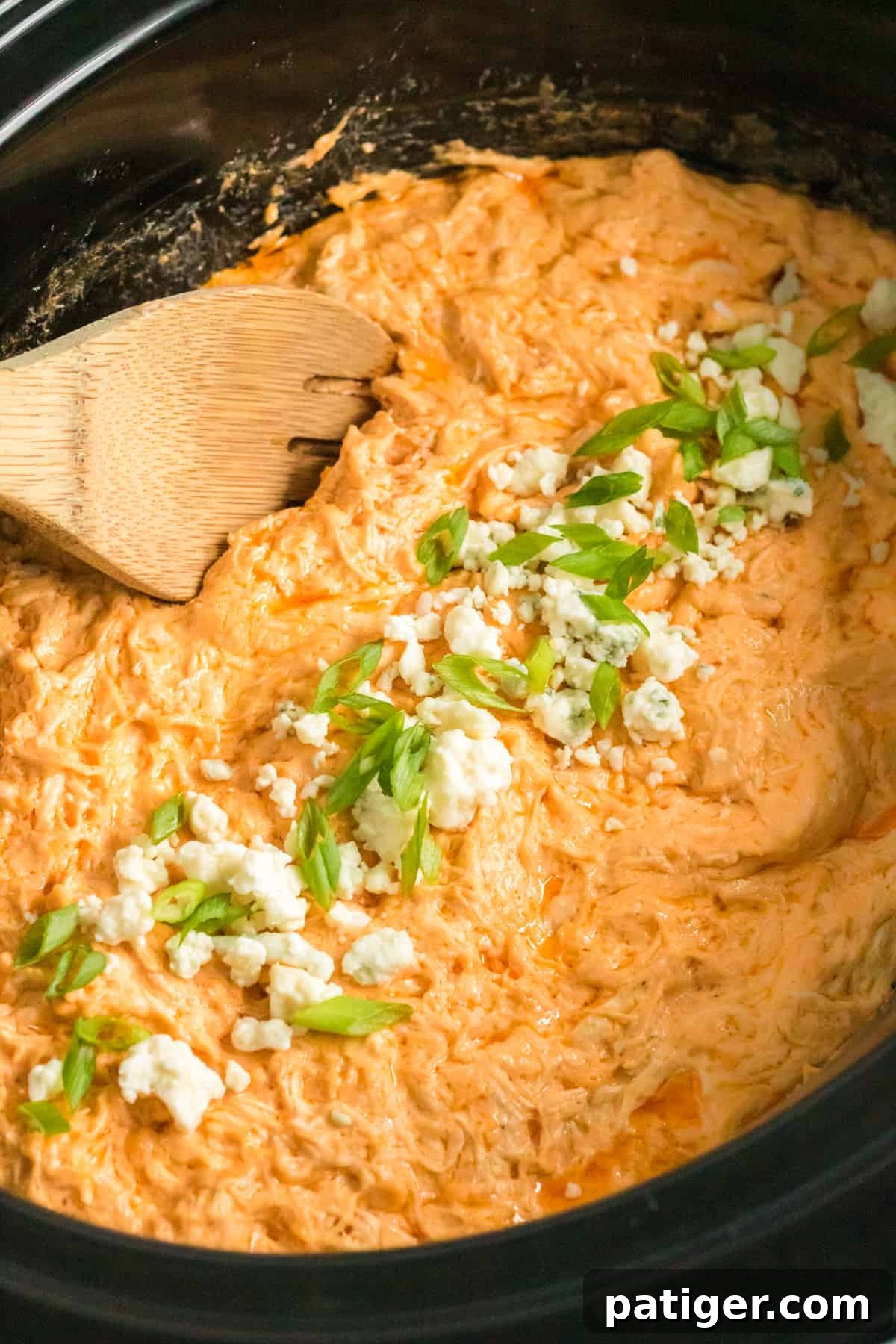 Game Day Crockpot Buffalo Chicken Dip 6 Crockpot buffalo chicken dip with blue cheese and green onions on top, close-up.