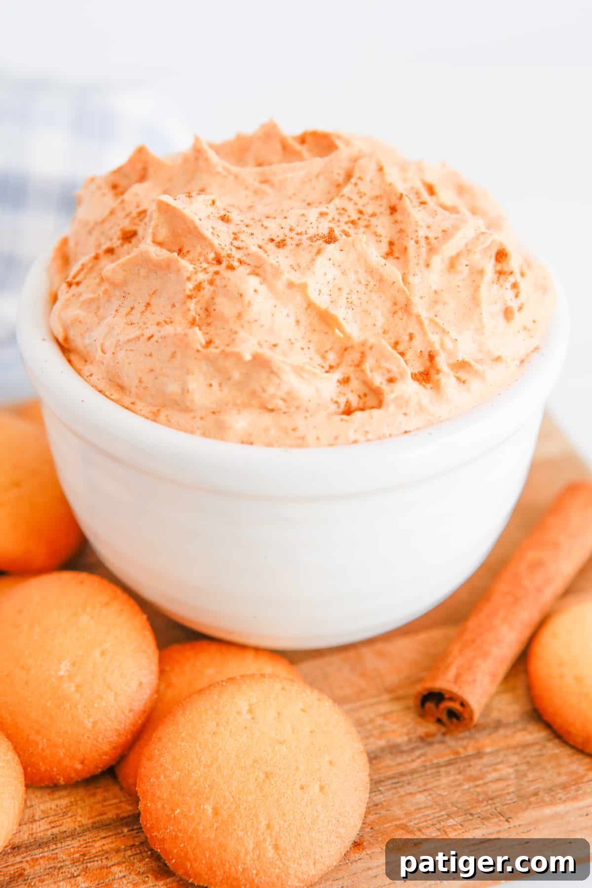 Pillowy Pumpkin Delight 5 A close-up shot of light and fluffy pumpkin fluff, showcasing its creamy texture, served alongside crisp vanilla wafers for dipping, ready to be enjoyed as a perfect fall treat.