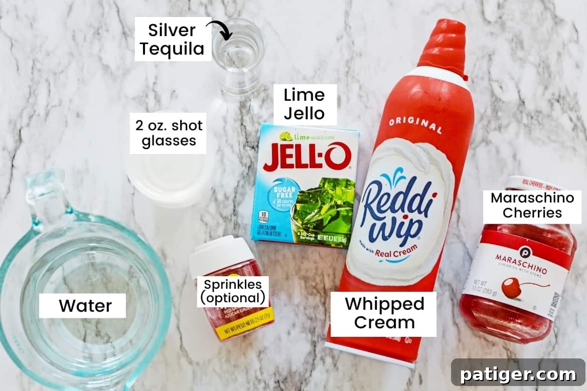 How the Grinch Stole Shots 3 A curated collection of ingredients for making Grinch Jello Shots, including a bowl of water, clear plastic shot cups, a bottle of silver tequila, a box of lime jello mix, a can of whipped cream, red sprinkles (optional), and a jar of glistening maraschino cherries.