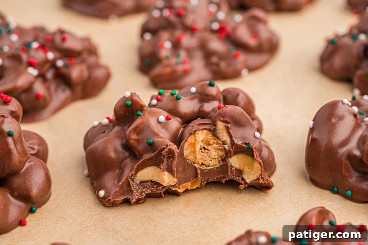3-Ingredient Crockpot candy with a bite taken out, revealing peanuts and a crunchy center.