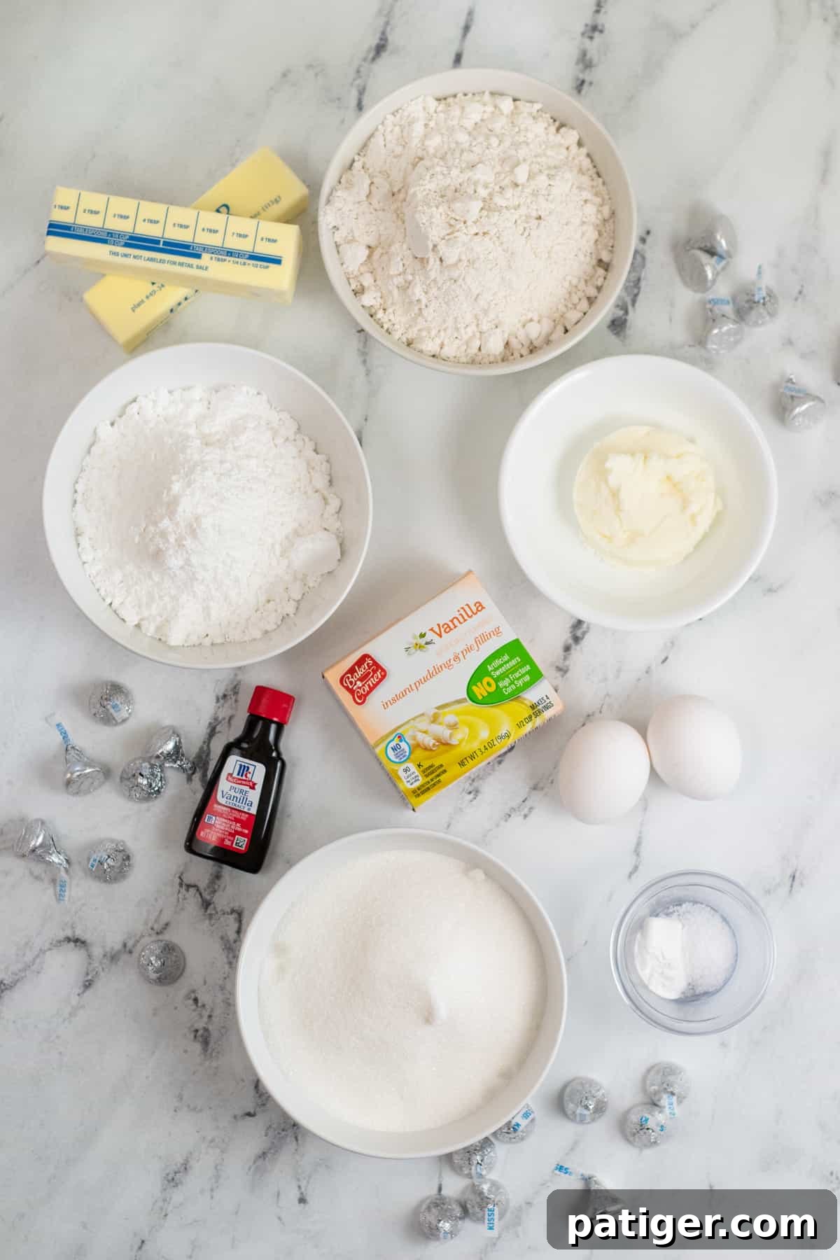 Ingredients on countertop: two sticks of butter, flour, granulated sugar, shortening, vanilla extract, box of vanilla instant pudding, 2 eggs, salt, baking powder, and milk.