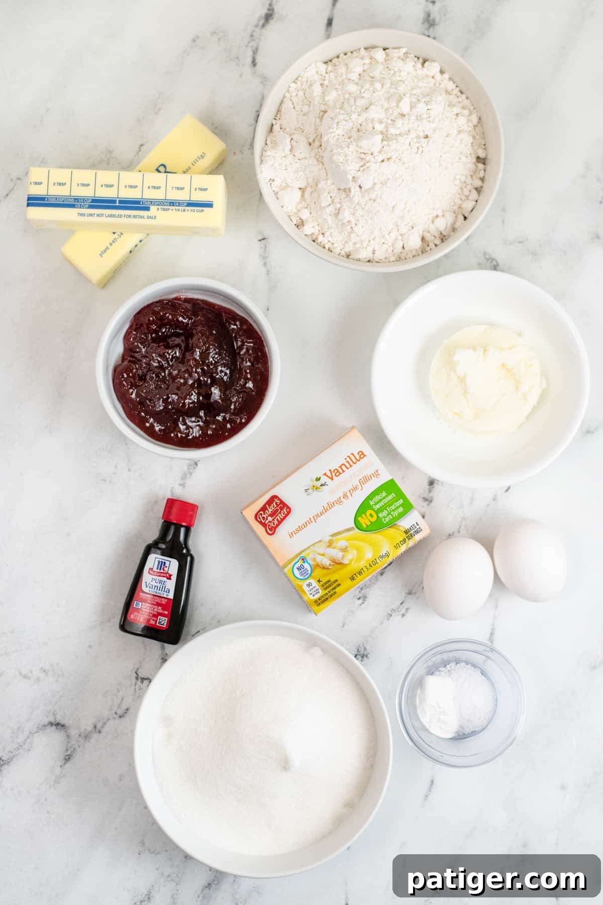 Dreamy Pudding Thumbprints 5 A countertop display of all necessary ingredients: two sticks of butter, flour, shortening, eggs, vanilla pudding mix, salt, baking powder, granulated sugar, and strawberry jam.