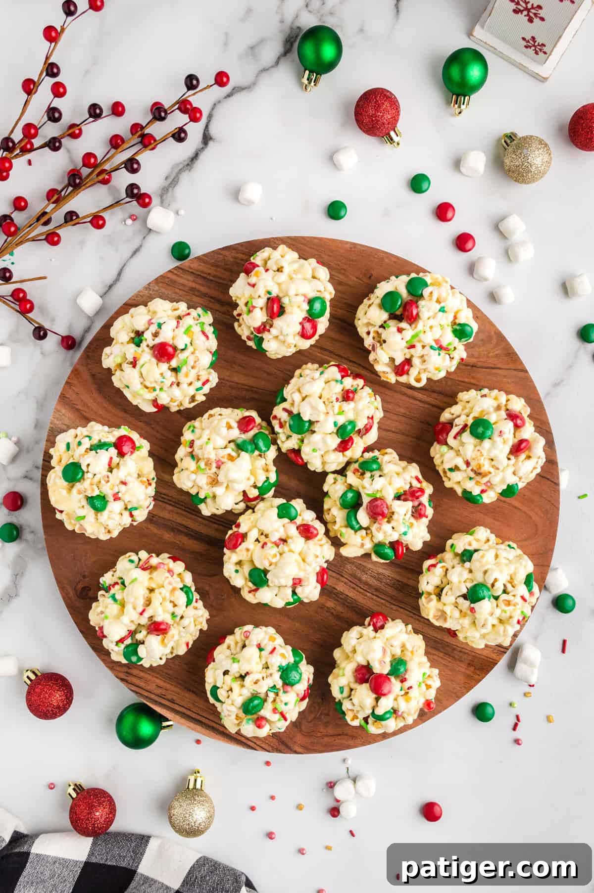 Christmas Popcorn Balls with M&Ms and sprinkles arranged on a festive round serving platter.
