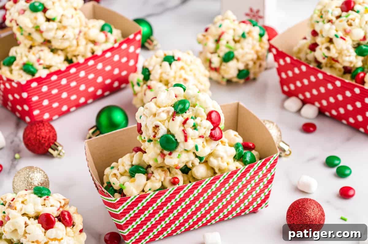 Several Christmas Popcorn Balls, decorated with M&Ms and sprinkles, nestled in charming paper gifting containers, ready for sharing.