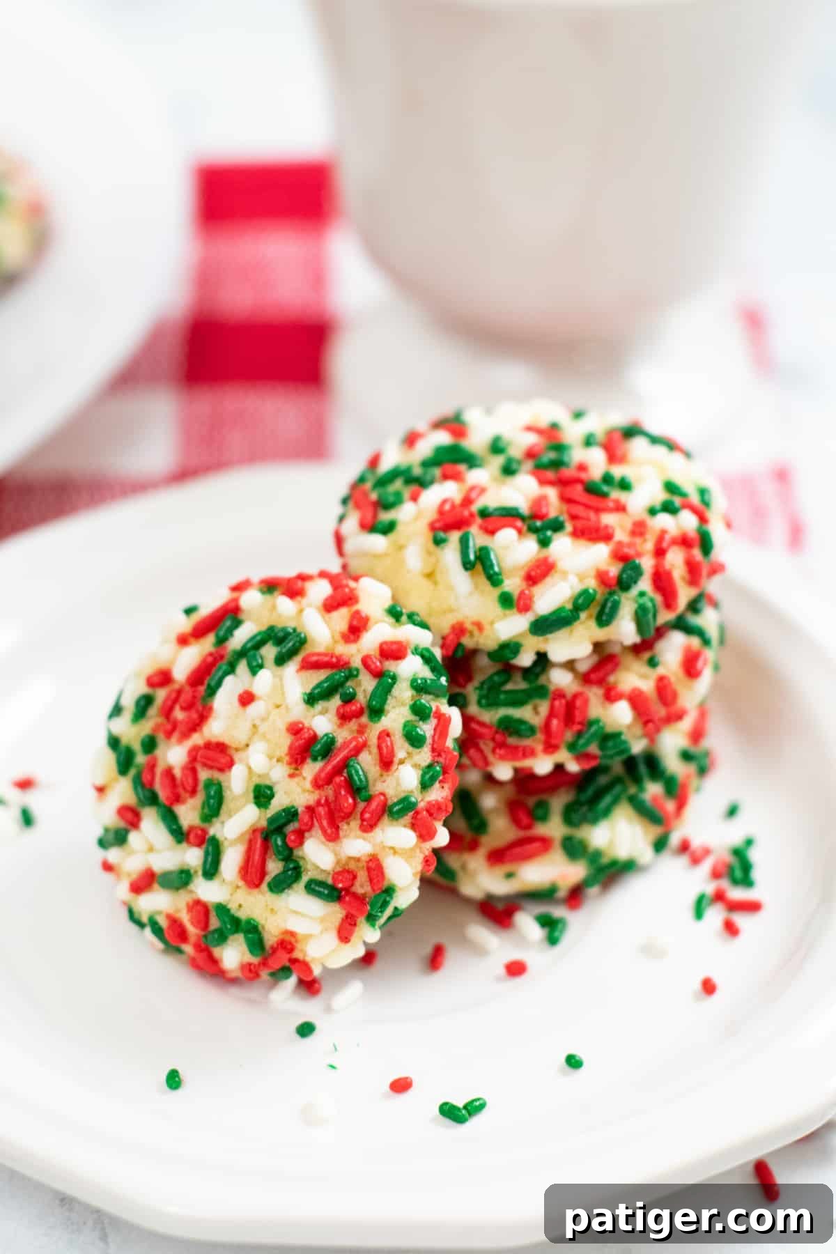 Sprinkle pudding cookies stacked 3 cookies on top of one another, with one cookie leaning on its side.