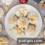 Soft Amaretti Cookies piled on a white plate surrounded by more cookies