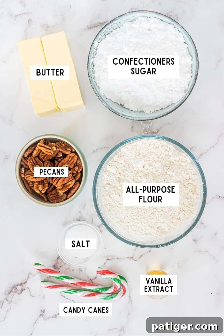 Crimson Swirl Snowball Delights 4 A flat lay of all the essential ingredients for Peppermint Candy Cane Snowball Cookies: two sticks of butter, a bowl of confectioners sugar, a bowl of all-purpose flour, chopped pecans, vanilla extract, salt, and two whole candy canes.