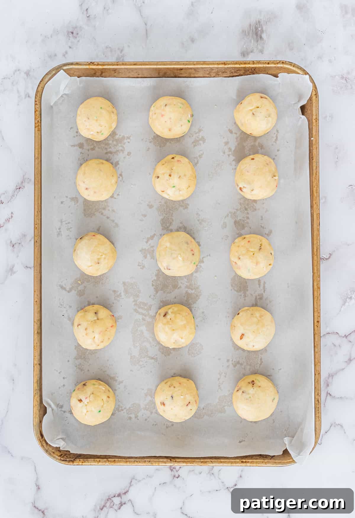 Crimson Swirl Snowball Delights 6 A baking sheet filled with freshly baked Snowball Cookies, prior to being dusted with powdered sugar, showcasing their light golden bottoms.